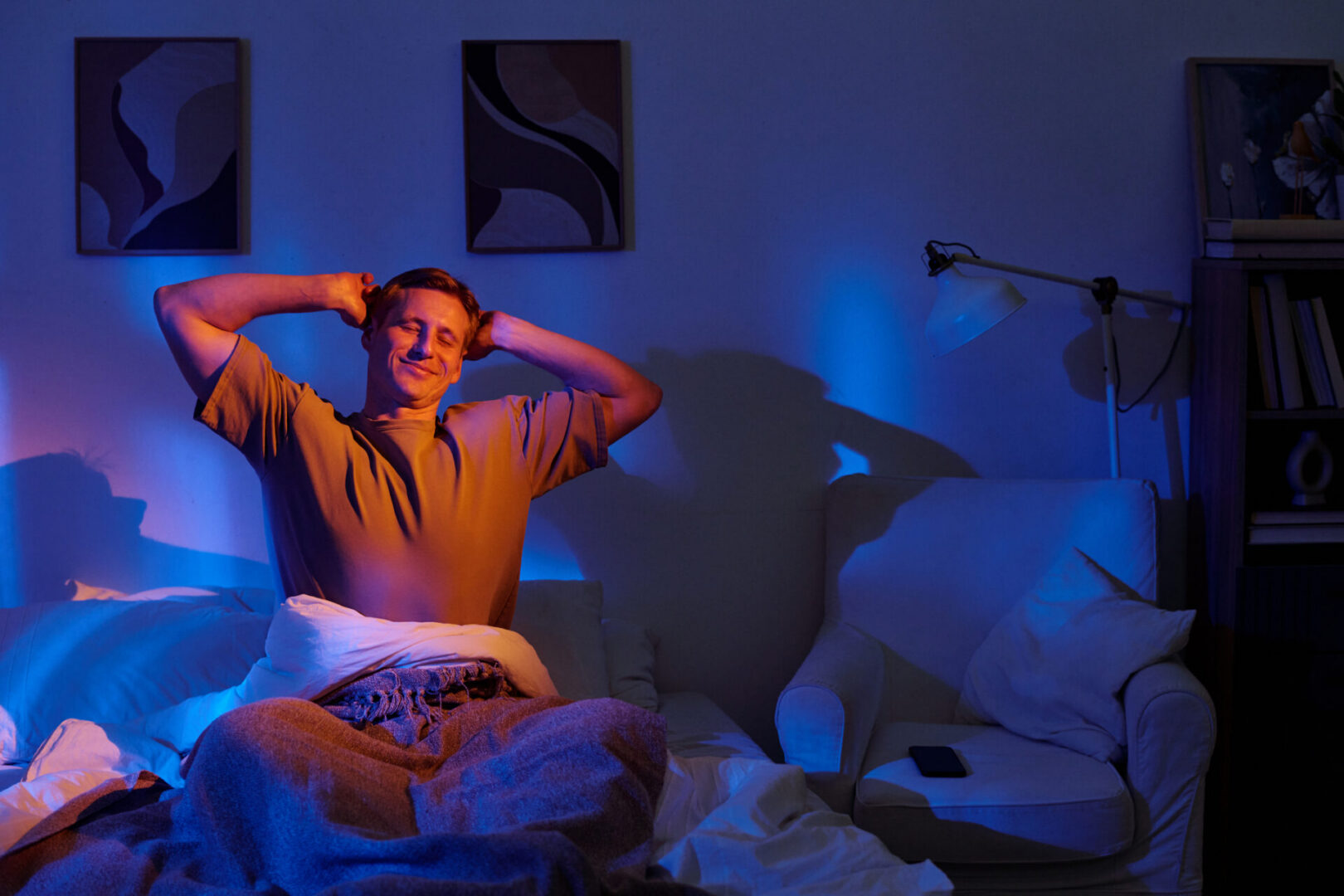 Man stretching and smiling in a cozy room.